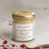 Jar of body salve with saffron, rose, and vetiver on a neutral background